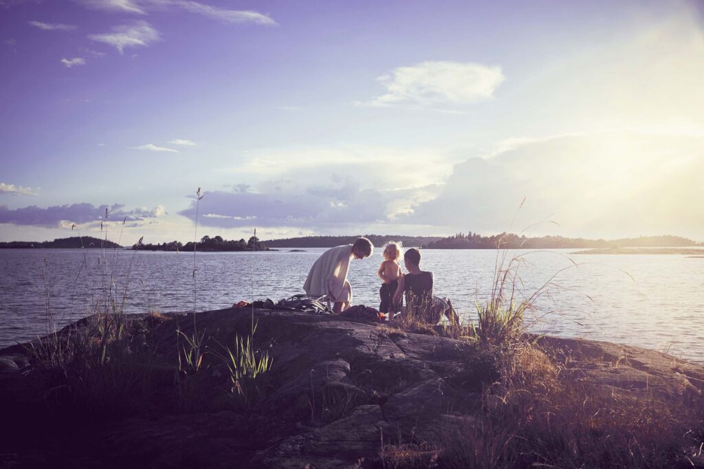 Sommrig bild med familj som badar